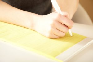 woman about to write yellow letters with white pen